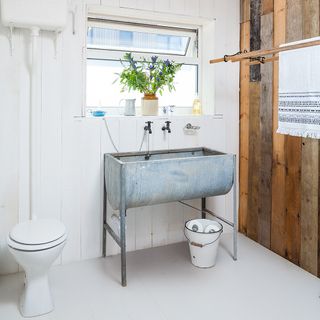room with wooden walls white wooden flooring and sink