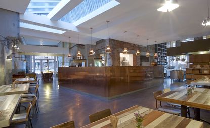Open plan restaurant and bar, exposed brick and concrete walls, low hanging light fixtures