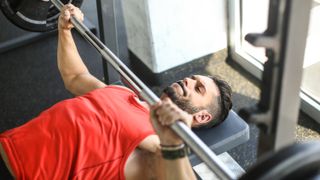 a photo of a man performing a barbell bench press