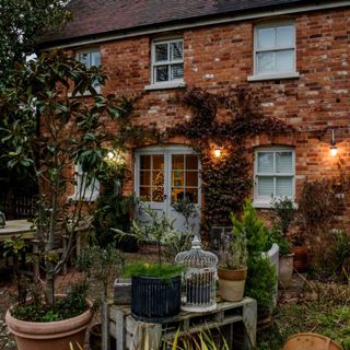 Front of Holly Lodge Cottage in the evening with external lights on. A renovated and extended Victorian cottage in the countryside near Henley On Thames with four bedrooms and guest accomodation, home of Gabriella Barren Williams and Stuart Burgess and their son.