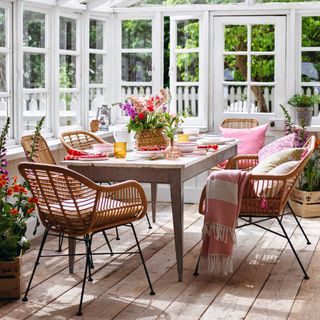 Daytime dining in white conservatory with dinnerware on top of dining table