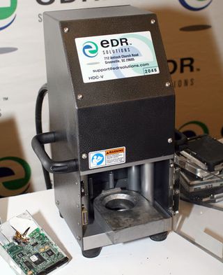 EDR Solutions sells this therapeutic drive crusher. The machine punches out the center spindle and deforms all the platters of a hard drive.