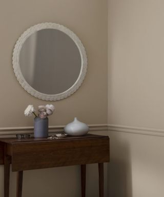 Beige walls with mirror and table