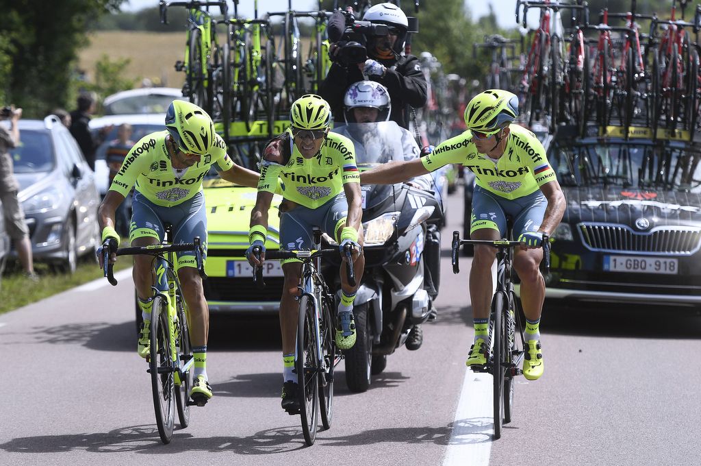 Alberto Contador is helped back into the peloton by his Tinkoff teammates after his stage one crash