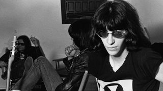 Singer Joey Ramone (1951 - 2001), of American punk group The Ramones, backstage at the Paradise Theater (now the Paradise Rock Club) in Boston, Massachusetts, 22nd March 1978. In the background are bassist Dee Dee Ramone (1951 - 2002, centre) and drummer Tommy Ramone (1949 - 2014).