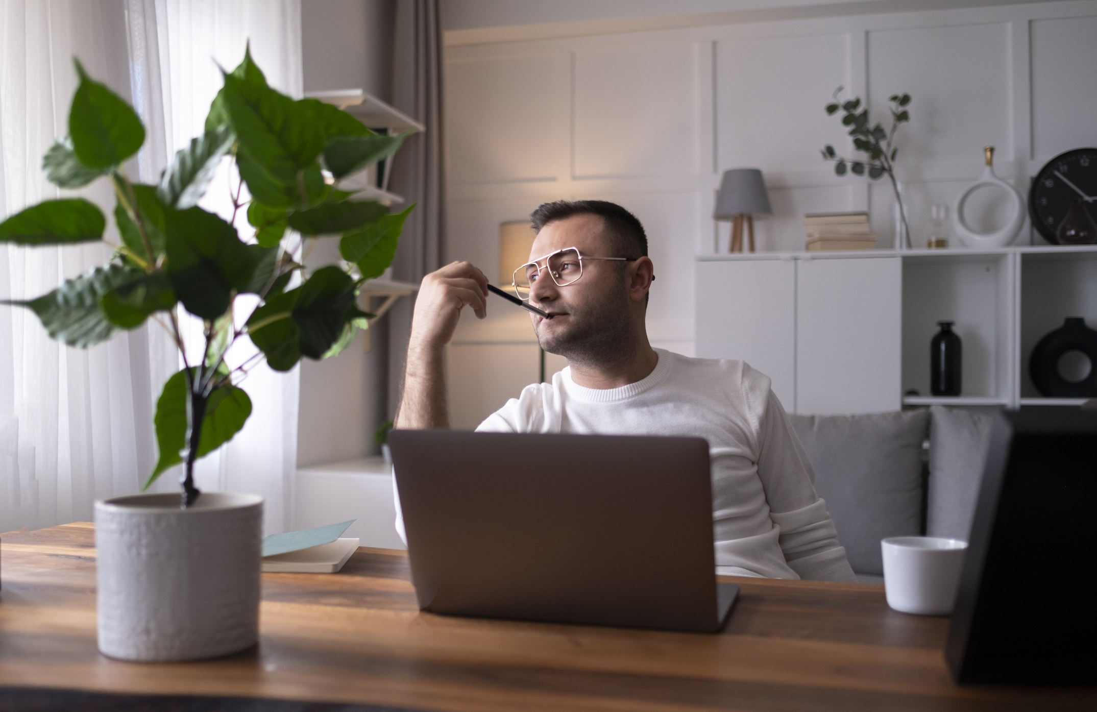 Man working on laptop deciding whether to sell a stock