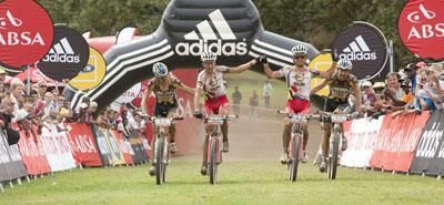 Christoph Sauser and Burry Stander of Team Songo-Specialized by DCM celebrate coming in second, with a friendly push from yellow jersey holders Stefan Sahm and Karl Platt of Team Bulls 1