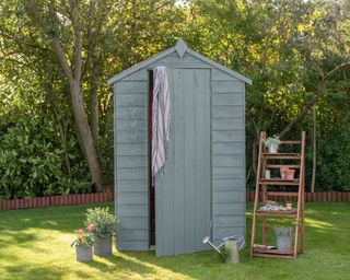 Garden shed shown painted in a green colorway on a summers day