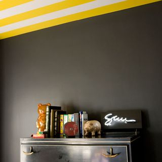 black bedroom with yellow and white striped ceiling