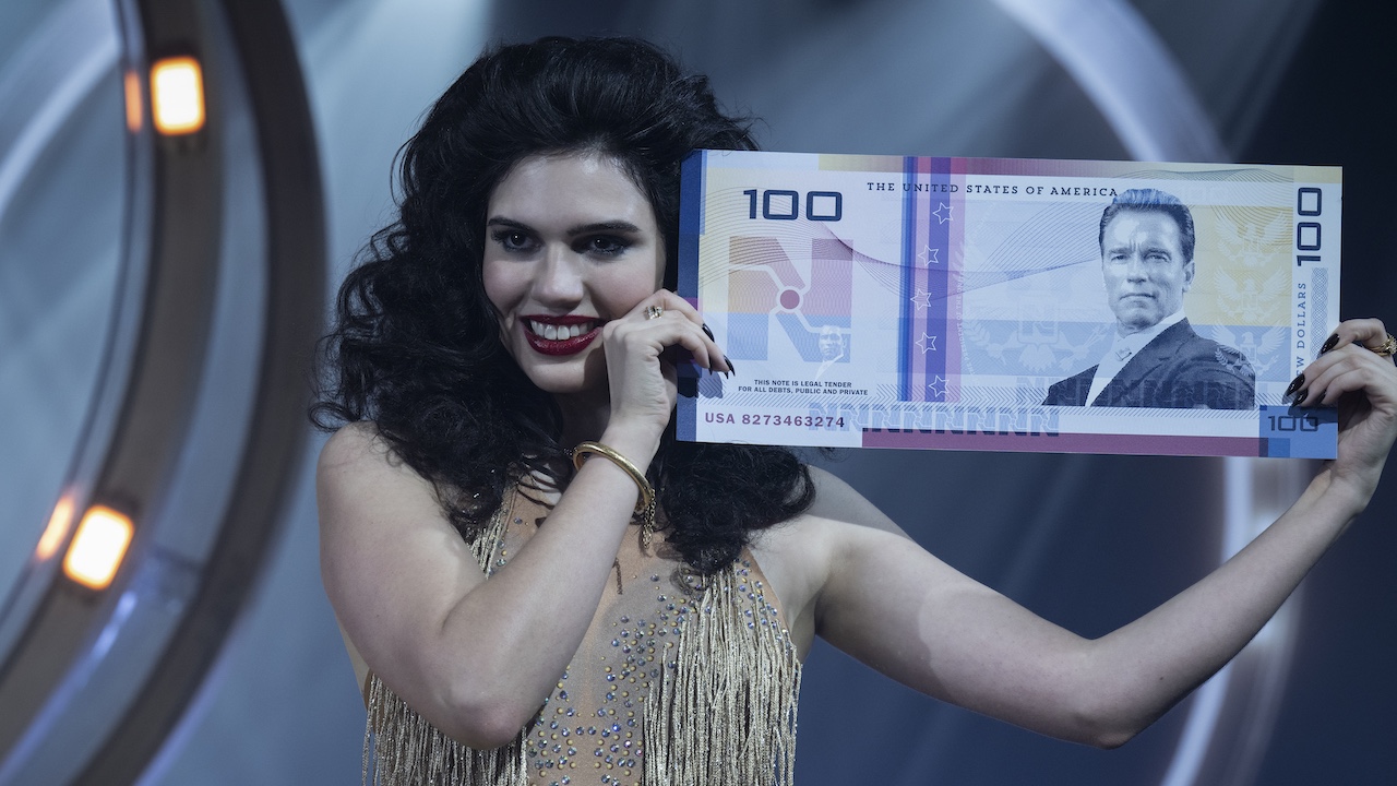 Woman holding up massive 100 bill with Arnold Schwarzenegger on the bill in 2025&#039;s The Running Man