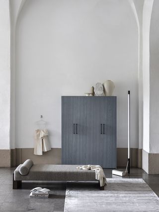 grey cupboard and a grey day bed in a large room