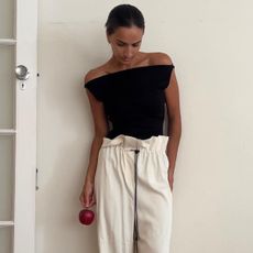 woman in chic black top and white pants