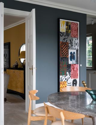 Dining room with colorful artwork painted in Farrow & Ball Down Pipe