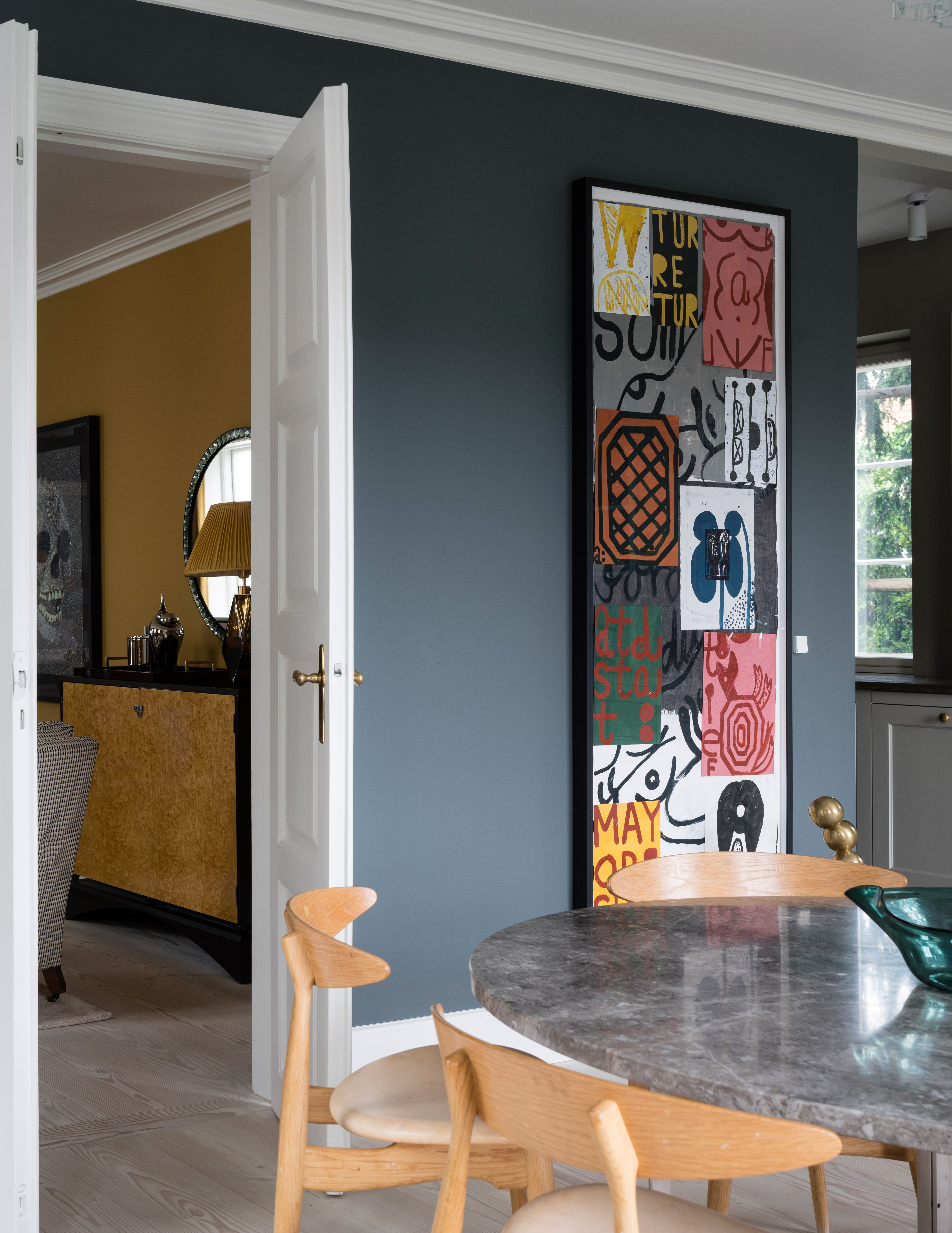Dining room with colorful artwork painted in Farrow & Ball Down Pipe