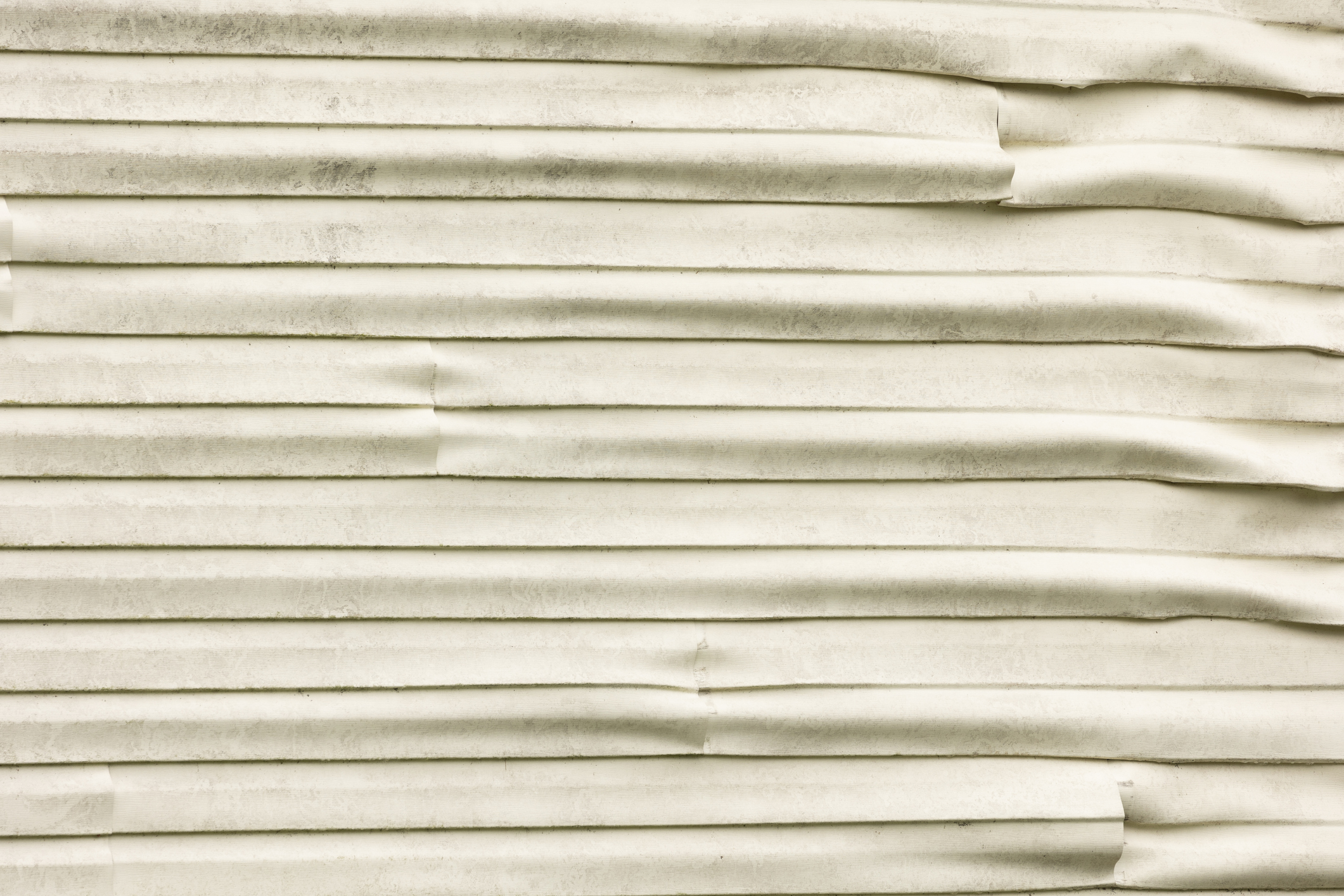 A close up of warped siding on a house.
