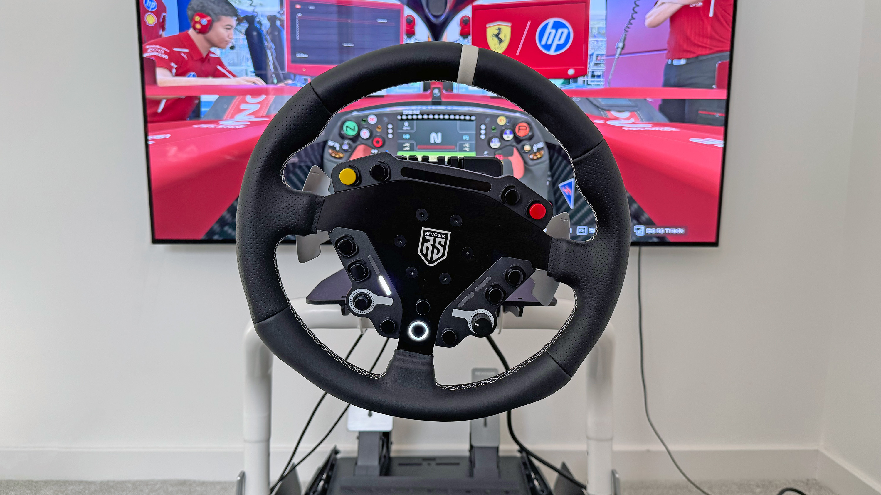 The Nacon Revosim RS Pure bundle&#039;s steering wheel in front of a TV