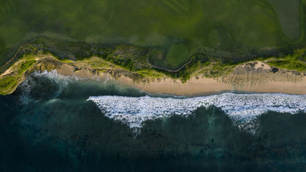 A bird&amp;#039;s eye view of the sea meeting a beach