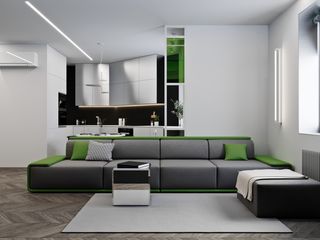 A dark grey couch with green pillows