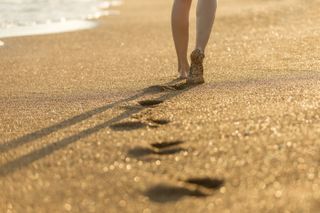 sand on feet, beach, woman walking