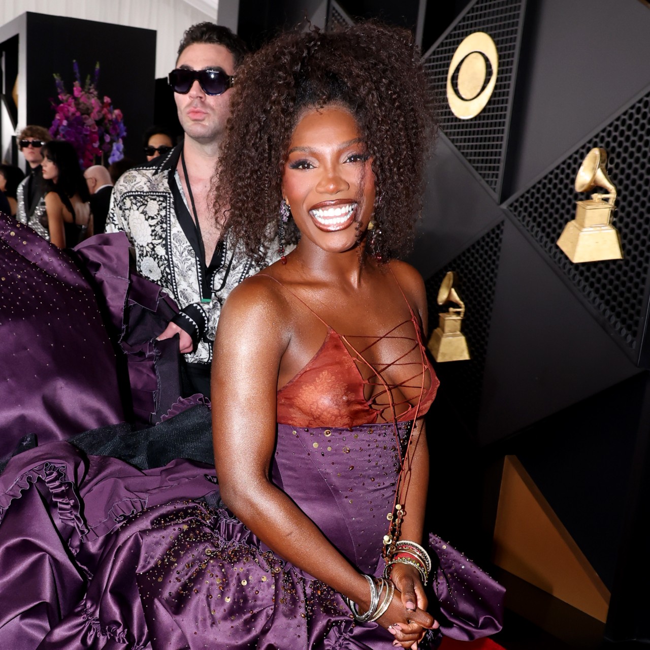a black woman with brown hair poses on the grammys red carpet
