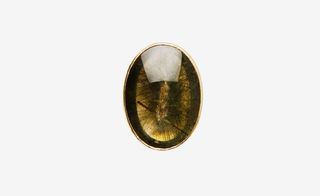 Oval green/gold precious stone set into a gold casing