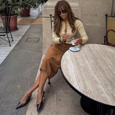 @slipintostyle wearing a cardigan with a suede pencil skirt and black pumps.