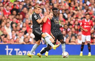 Christian Eriksen of Manchester United is fouled by Martin Oedegaard of Arsenal during the Premier League match between Manchester United and Arsenal FC at Old Trafford on September 04, 2022 in Manchester, England. (Photo by Michael Regan/Getty Images)