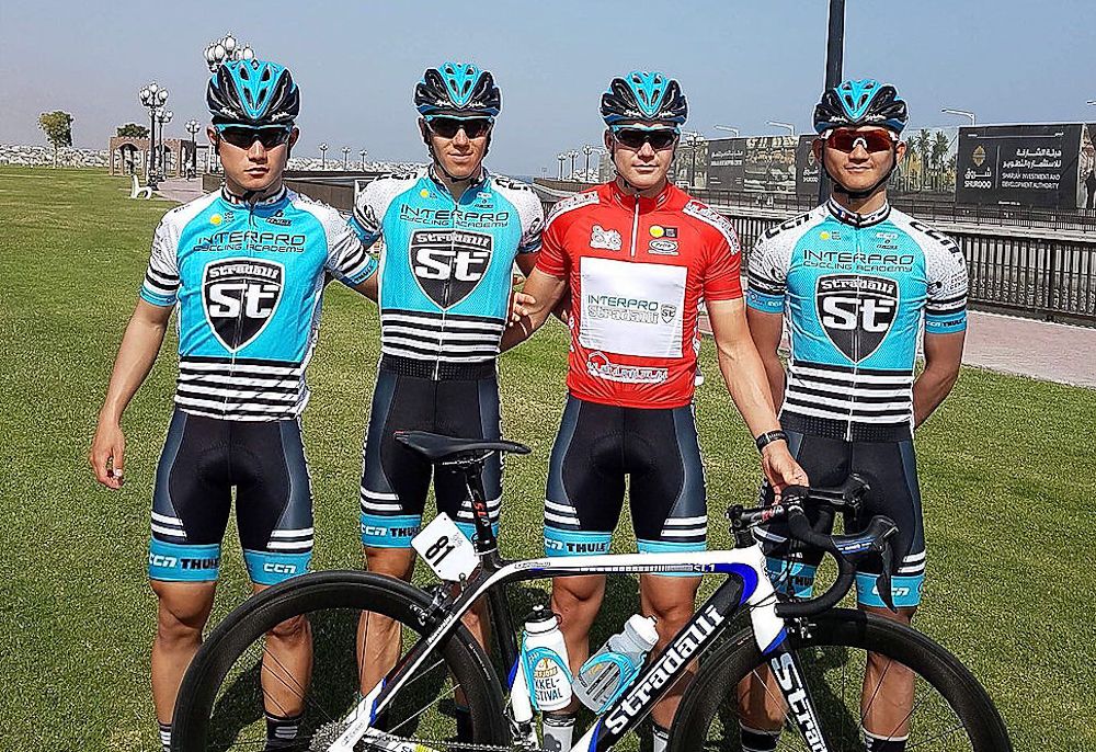 Interpro Stradalli riders pose with teammate Ken Levi Eikland after the Norwegian took the red mountains jersey during stage 2 at the Sharjah Tour