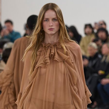 Chloe model wearing a tan sheer ruffled dress at the F/W 24 show.