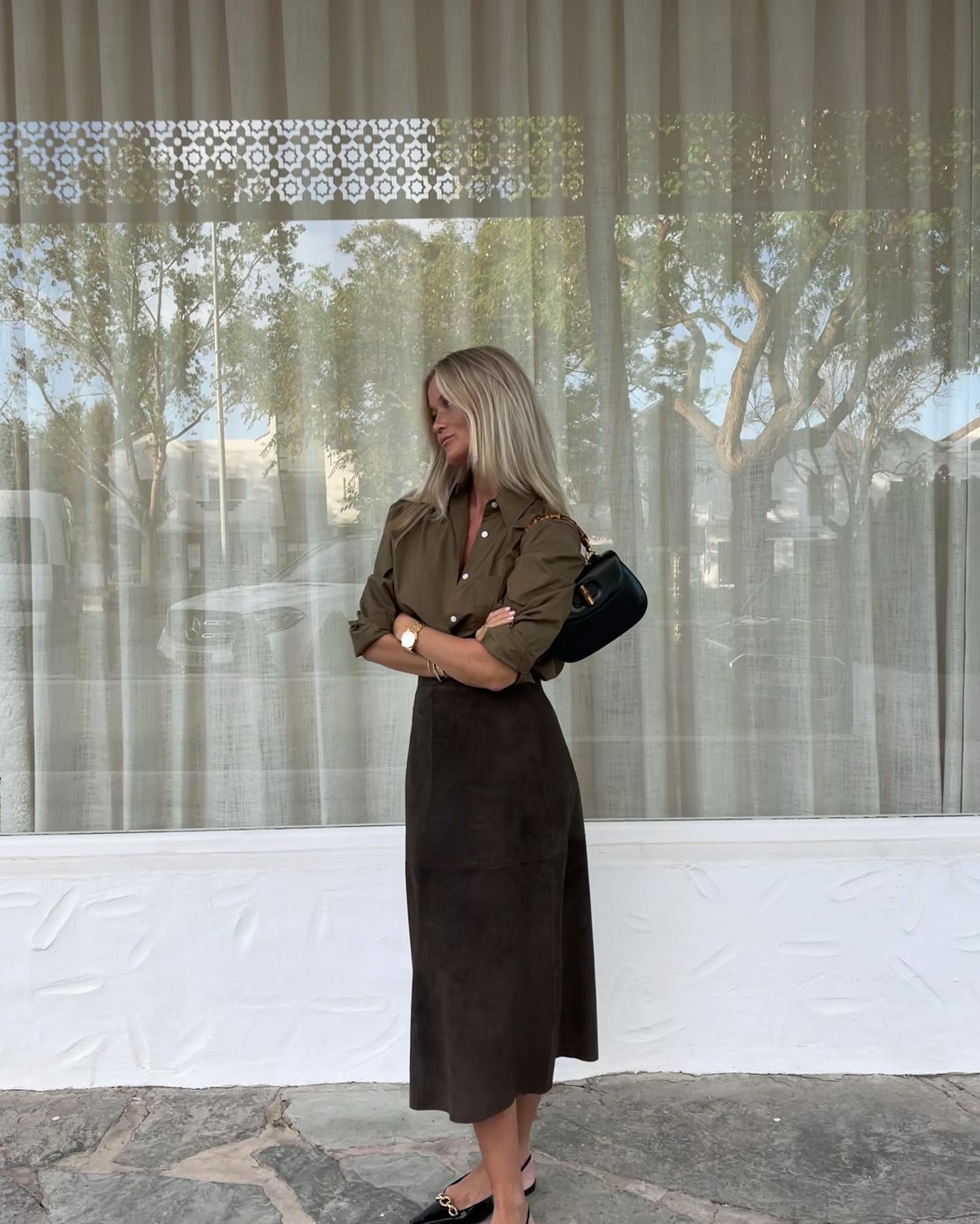 An image of @josefinehj wearing a khaki button down with a khaki suede skirt.