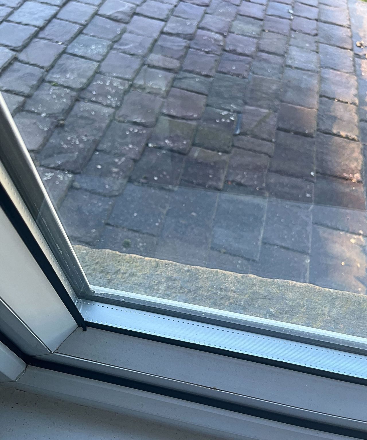 A window with dirt and hard water stains on it