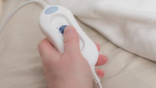 a person using the remote on an electric blanket