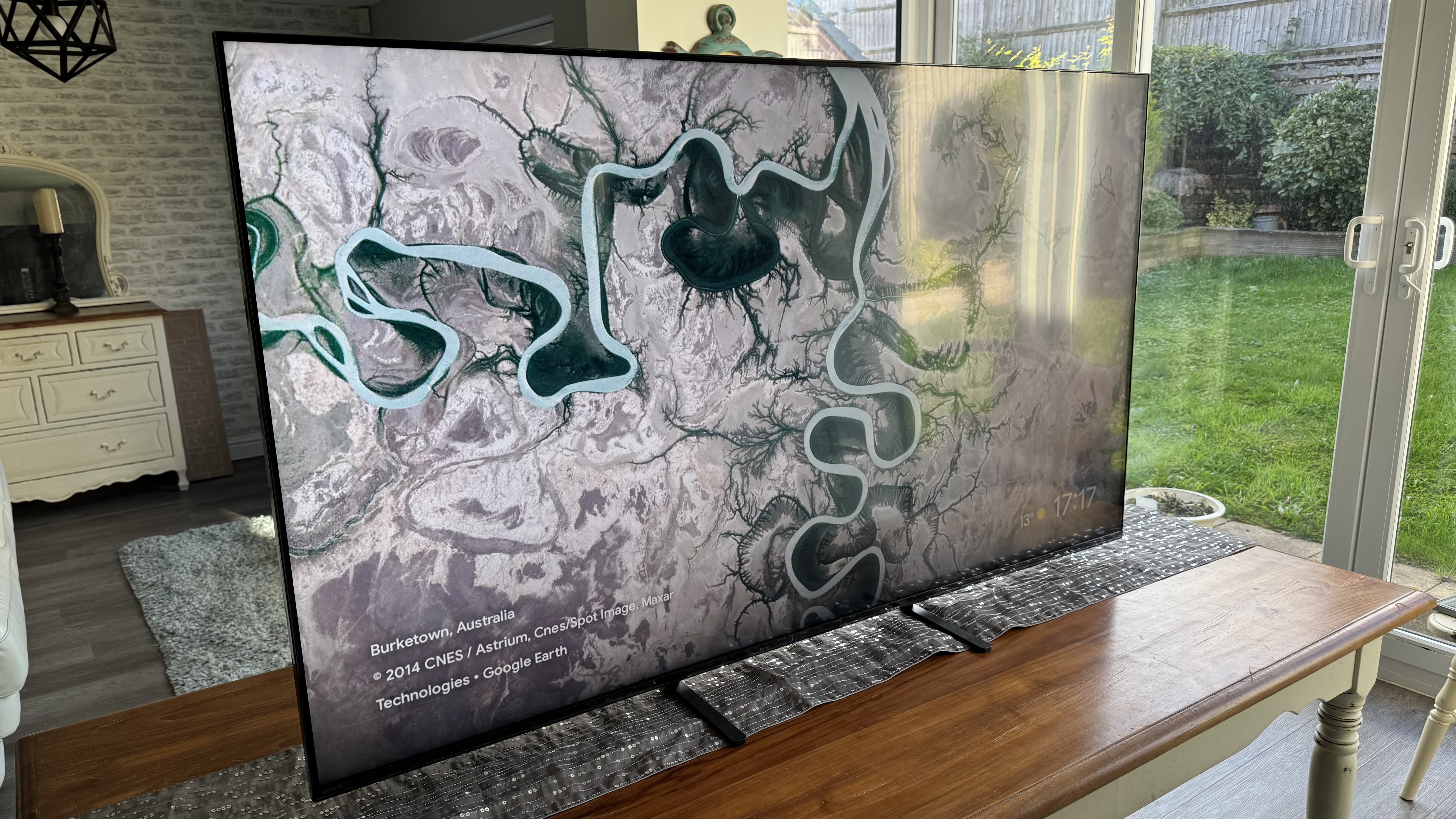 The Sony 65 Bravia 5 from a left angle, pictured on a wooden cabinet