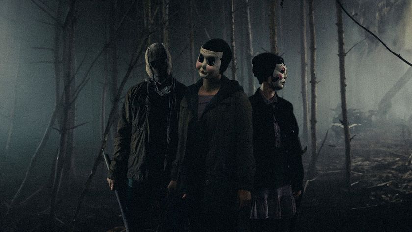 Three creepy masked figures stand side by side in a forest with a grainy filter over the top
