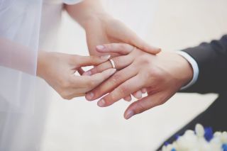 A close-up of a couple exchanging rings at their wedding