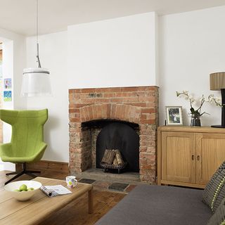 living room with stone fireplace and white wall