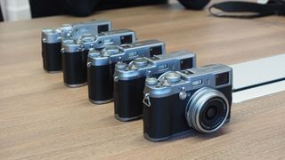 five Fujifilm X100V lined up on a table