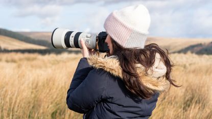 a woman using a camera outside