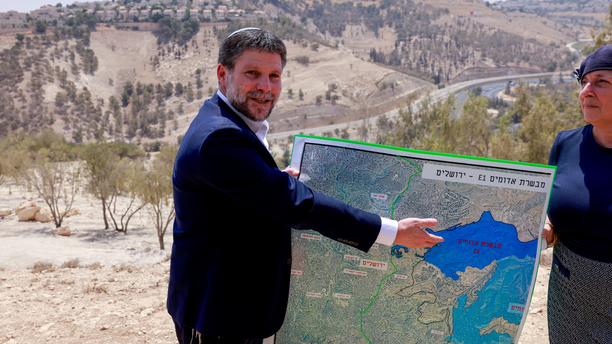 Bezalel Smotrich displays a map of the area around the land corridor known as E1