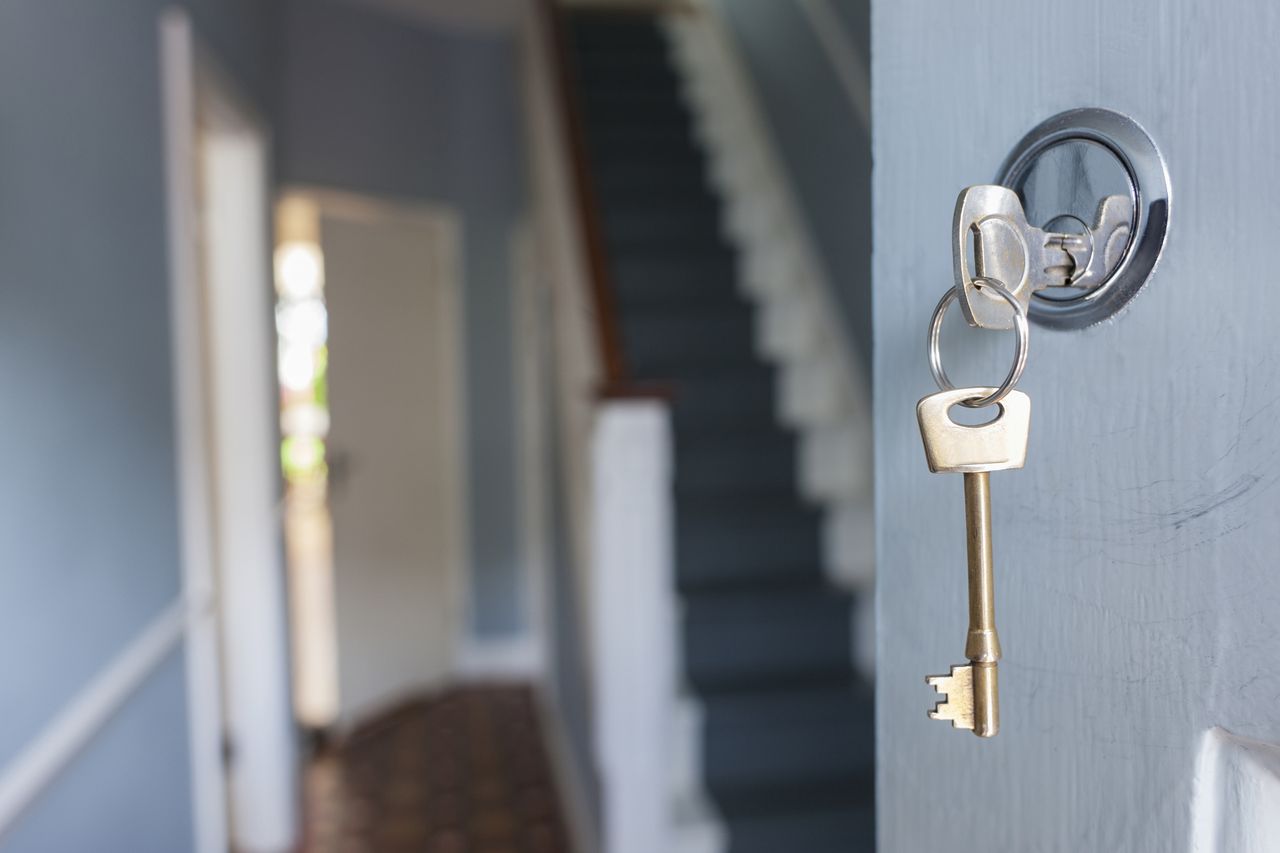 A key unlocking the front door of a house. 