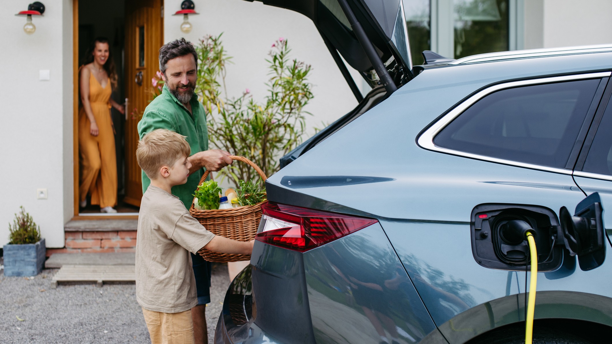a man and son load a picnic basket into an EV SUV