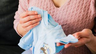 Woman holding baby clothes