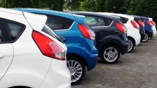 Cars lined up on an auto lot.