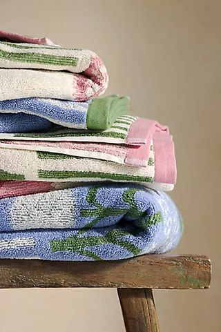 Ellen Merchant Cottage Towel Collection against a brown background.