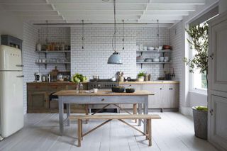 An open plan kitchen with a wooden island and brick walls