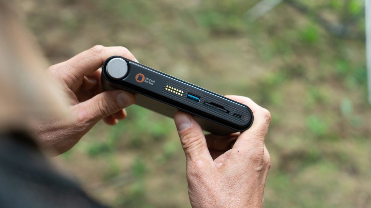 A lifestyle image of the PocketCloud in a person's hands and the small LCD screen and USB and SD drive
