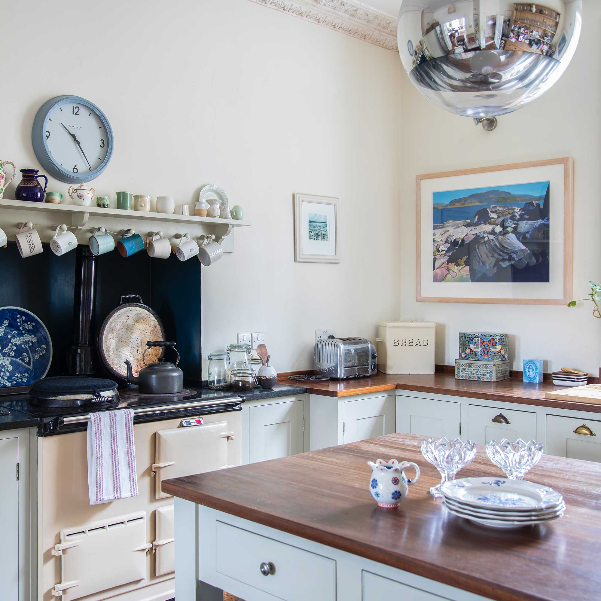 neutral painted kitchen with wooden worktops, cream range cooker and pale walls