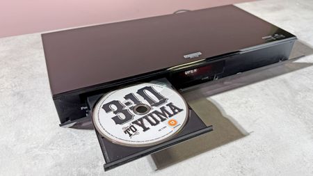 A Panasonic DP-UB820 4K Blu-ray player, with its disc tray open, and copy of 3:10 to Yuma on 4K Blu-ray disc in the tray