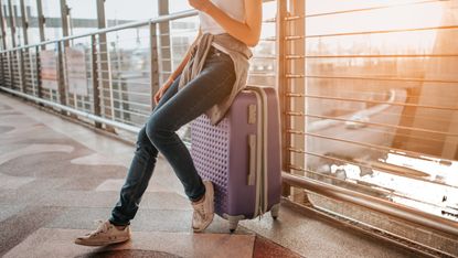 Woman reclining on a suitcase in the airport