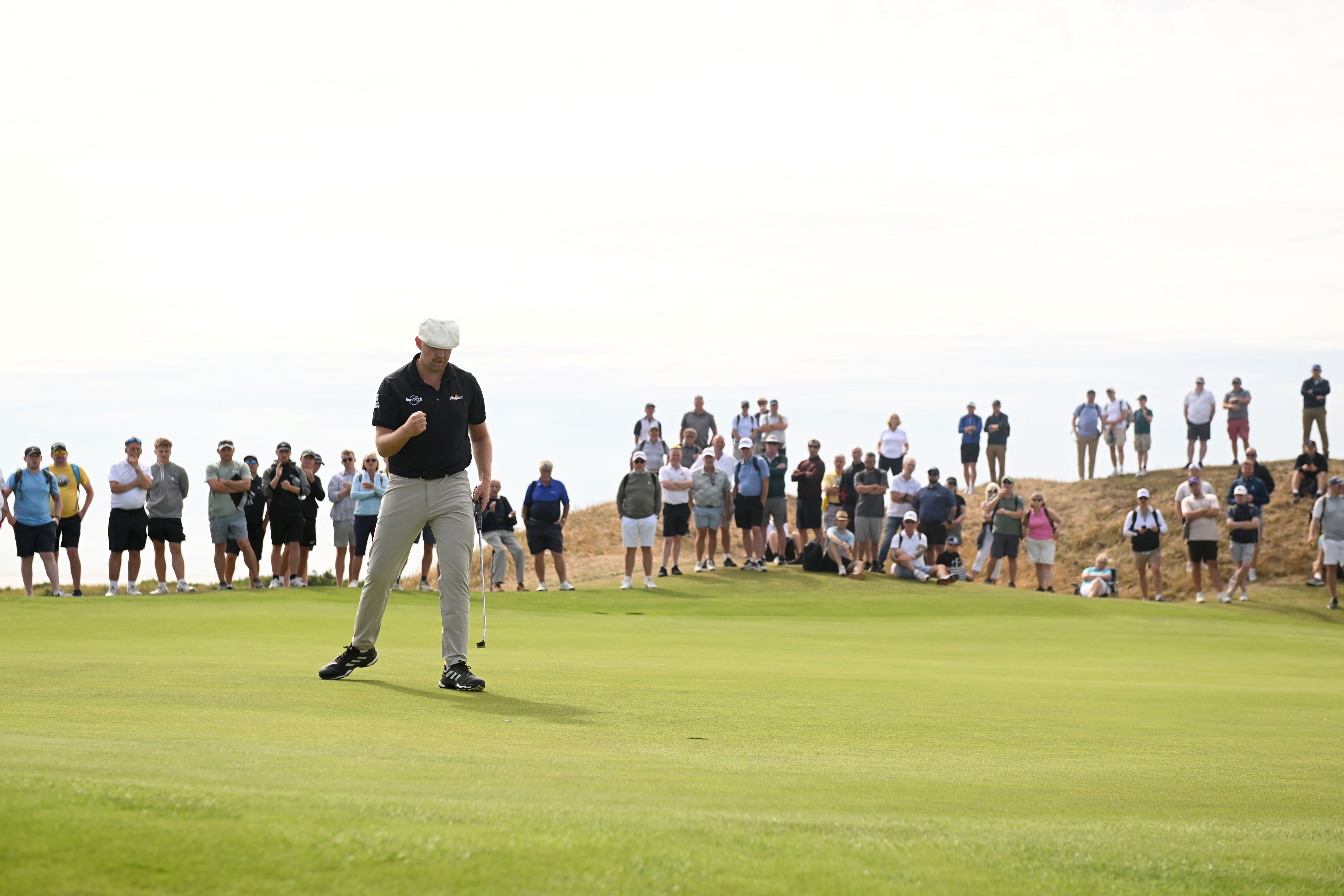 Harry Hall fist pumps after holing a putt